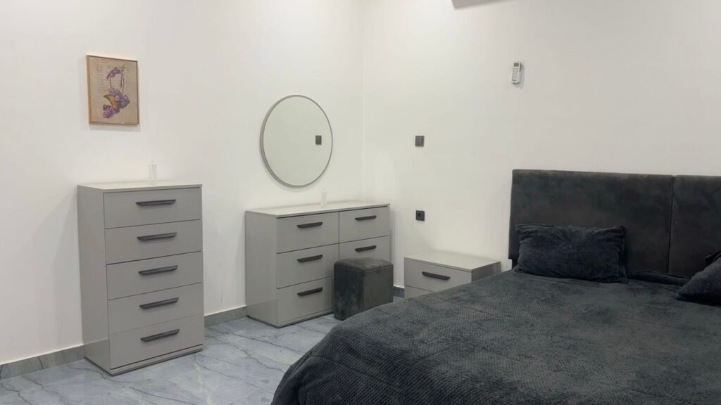 Furnished master bedroom with grey velvet bed and modern storage in حي الجامعي, Benghazi