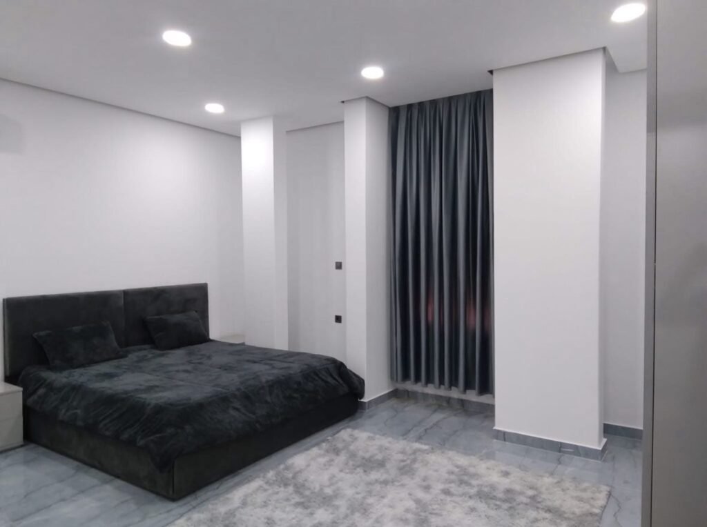 Furnished master bedroom with grey velvet bed and modern storage in حي الجامعي, Benghazi