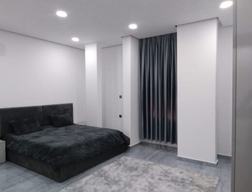 Furnished master bedroom with grey velvet bed and modern storage in حي الجامعي, Benghazi