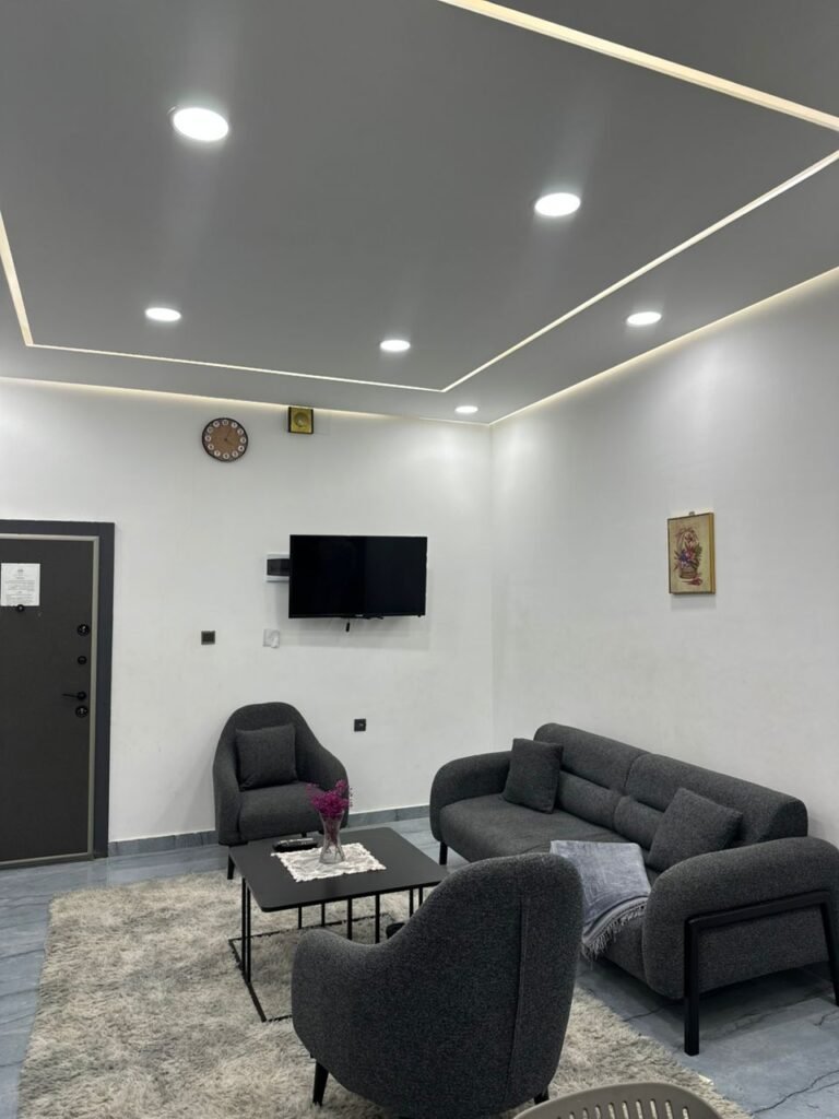 Modern furnished living room with flat-screen TV and grey sofa set in حي الجامعي apartment near Benghazi University